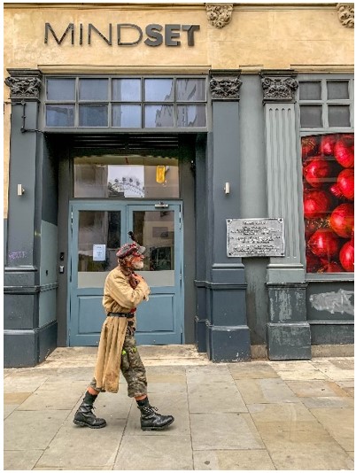 Street photography by David Swainsbury -  a man walking in front of a shop