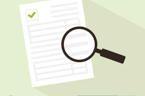 A white sheet of paper with a green tick and a magnifying glass. 