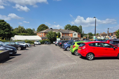 Back Lane Car Park, showing cars parked in a row outside and near the Rochford Hotel in the background.